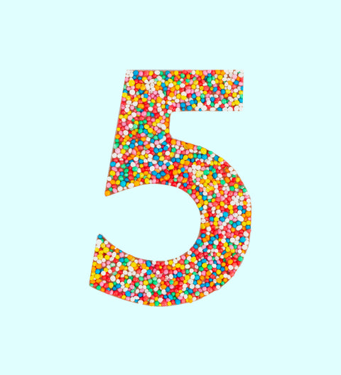 Belgian milk chocolate in the shape of the number 5, covered with multicolored sprinkles.