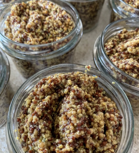 Glass jars filled with a textured brown and beige substance on a light surface.