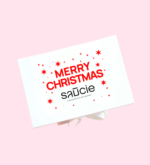 Merry Christmas card with 'saucie' branding on a pink background