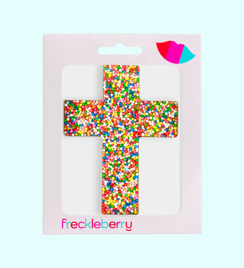 Colorful cross-shaped hair accessory in packaging with 'freckleberry' branding on a light pink background.