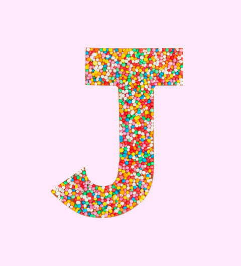 Belgian milk chocolate letter 'J' covered with multicolored sprinkles on a white background