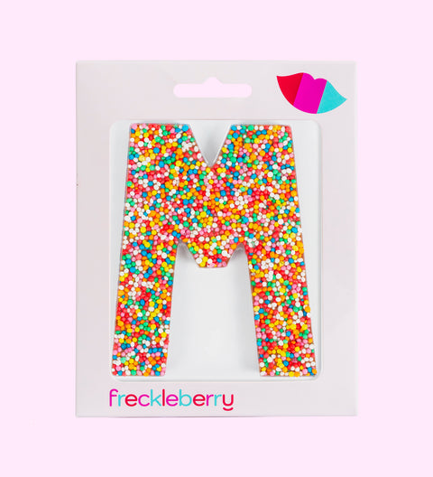Belgian milk chocolate letter 'M' covered with multicolored sprinkles on a white background