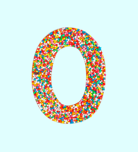 Belgian milk chocolate letter 'O' covered with multicolored sprinkles on a white background