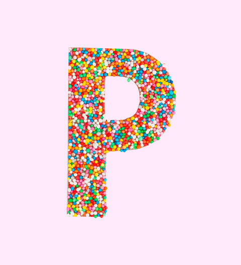 Belgian milk chocolate letter 'P', covered with multicolored sprinkles on a white background