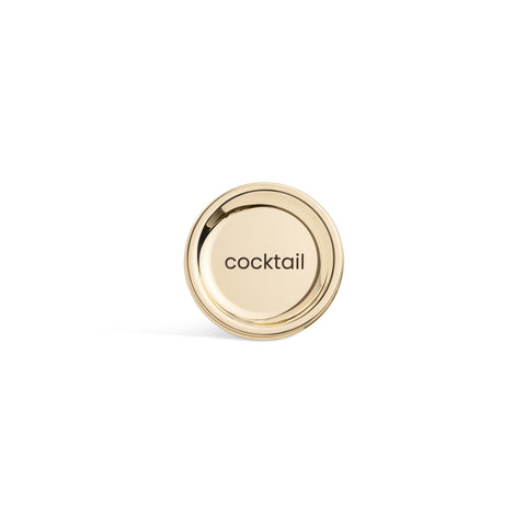 A tall, cylindrical white bottle with a brushed gold label disc at the bottom and a precision squeeze nozzle on the side. Cocktail Sauce