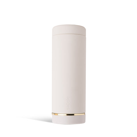 A tall, cylindrical white bottle with a brushed gold label disc at the bottom and a precision squeeze nozzle on the side. Condiments sauce bottle