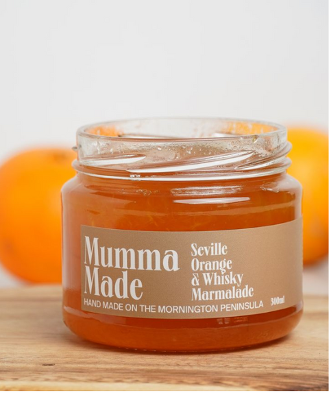 Jar of Mumma Made Seville Orange & Whisky Marmalade with oranges in the background