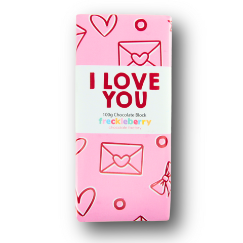 A wrapped chocolate block with a pink wrapper designed with hearts and the text 'I LOVE YOU'. The brand 'freckleberry' is visible.