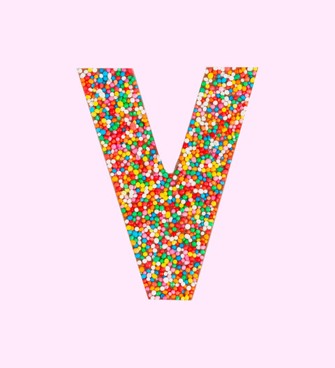 Belgian milk chocolate letter 'V' covered with multicolored sprinkles on a white background