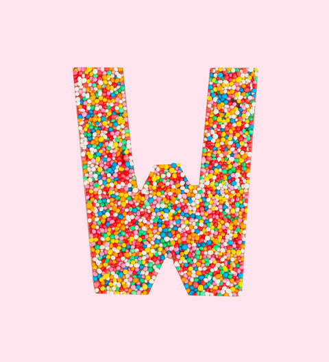 Belgian milk chocolate letter 'W' covered with multicolored sprinkles on a white background