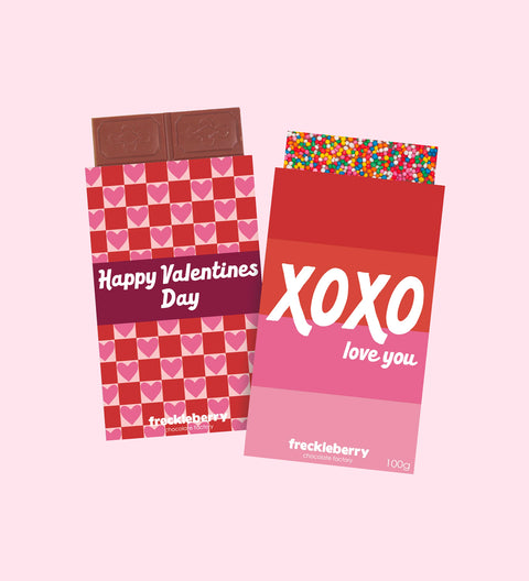 Two Assorted Chocolate Blocks with Valentine's Day themed wrapping. One with a red background and hearts pattern, and the other with a pink background and 'XOXO love you' text.