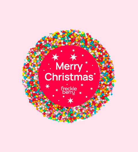 A colorful chocolate freckle with 'Merry Christmas' text and star decorations, individually wrapped.