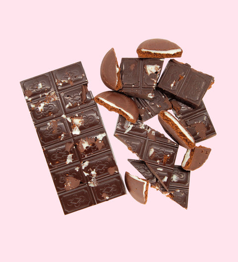 A dark chocolate block with visible pieces of biscuit and a minty touch on a white background.