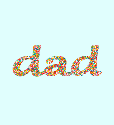 Handcrafted Belgian chocolate letters spelling out the word 'dad', decorated with colorful candy pieces.