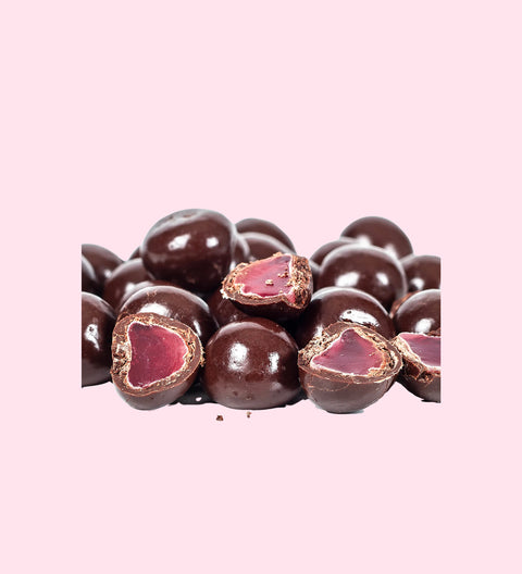 A cluster of dark chocolate coated raspberries with the inner raspberries visible in some of the chocolate coats.