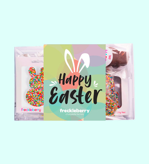 An Easter-themed gift box from Freckleberry featuring a chocolate bunny, marshmallow pops, and other Easter treats with 'Happy Easter' text displayed.