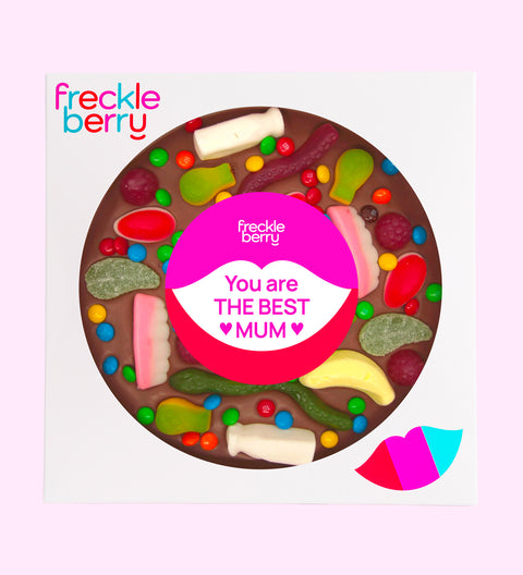 A giant chocolate pizza with various lolly toppings, including candies and gummy bears, with a 'Happy Mother's Day' message in the center.