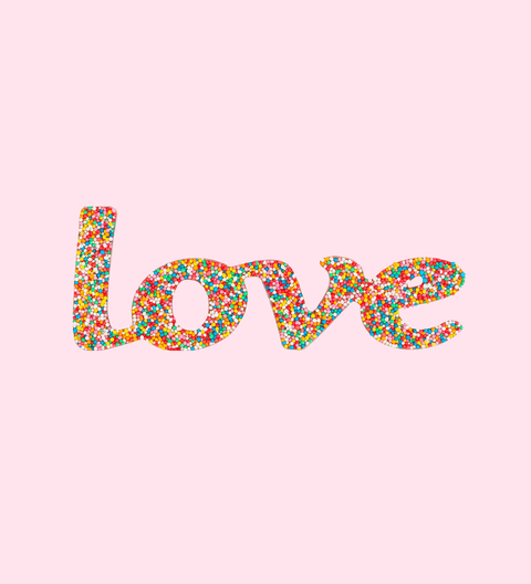 A colorful chocolate word 'LOVE' made with freckle-like patterns on a pink background.
