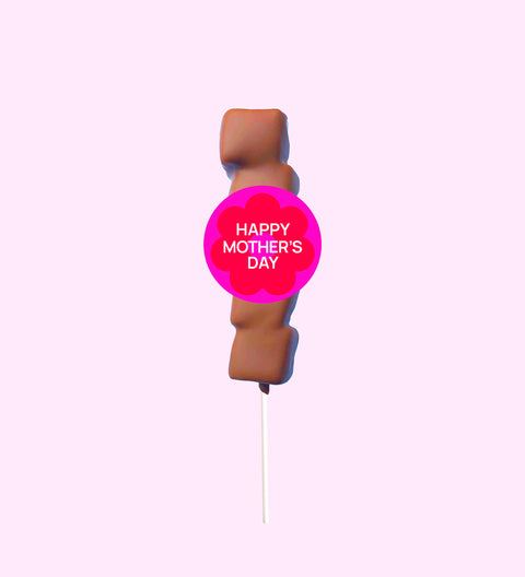 A marshmallow lollipop with a 'Happy Mothers Day' text badge, covered in Belgian milk chocolate drizzle on a pink background.