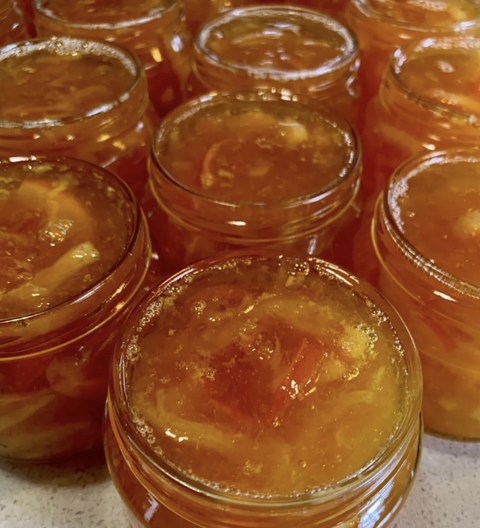 Jars of preserved fruit on a speckled countertop