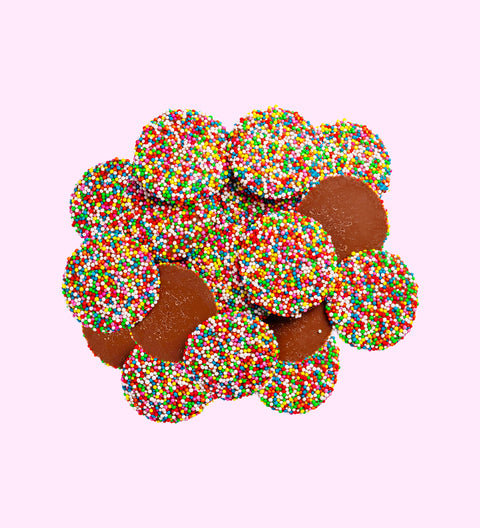 A pile of milk chocolate freckles with colorful sprinkles on top.