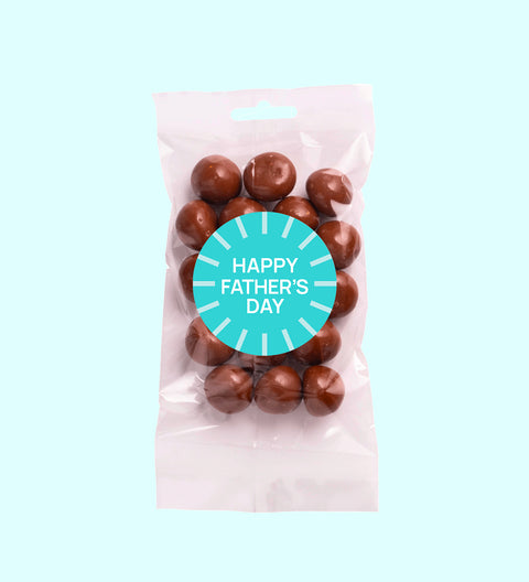 A clear plastic packaging containing milk chocolate coated raspberries with a 'Happy Father's Day' sticker on the front.
