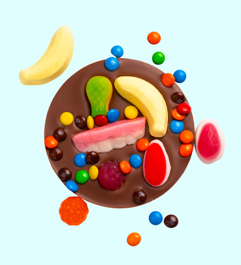 A mini chocolate pizza with various candy toppings, including chocolate pieces and colorful candies arranged in a playful manner.