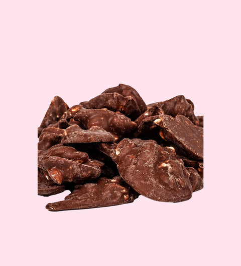 A pile of chocolate peanut clusters against a white background.