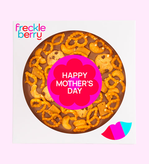 A snack large chocolate pizza with pretzels, chocolate chips, and nuts, topped with a 'Happy Mothers Day.