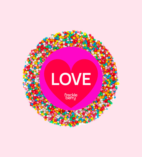 A colorful chocolate freckle with 'LOVE' text in the center, surrounded by multicolored sprinkles.