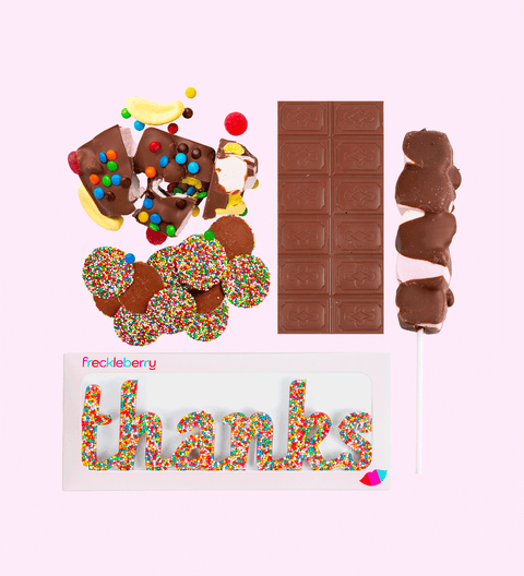 A variety of chocolate candies from Freckleberry Chocolate Factory, including a milk chocolate message block, fun rocky road, a milk freckle grab bag, mallow pop, and a freckle word that spells 'thanks'.