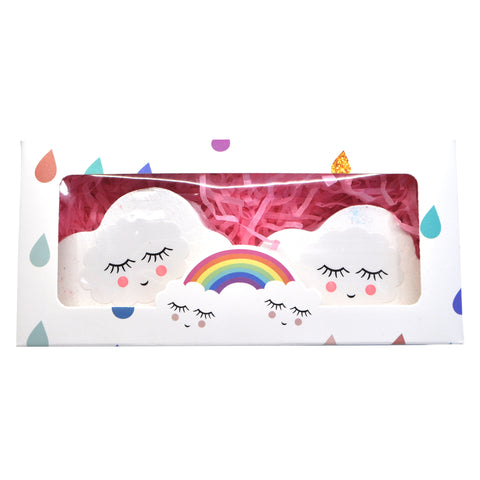 Two bath bombs with cloud and rainbow design in a white packaging box with colorful raindrop patterns.