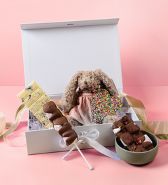 An indulgent selection of premium Belgian chocolates and pink bunny plush toy, customised for festive gifting to celebrate the coming of a new member of the family.