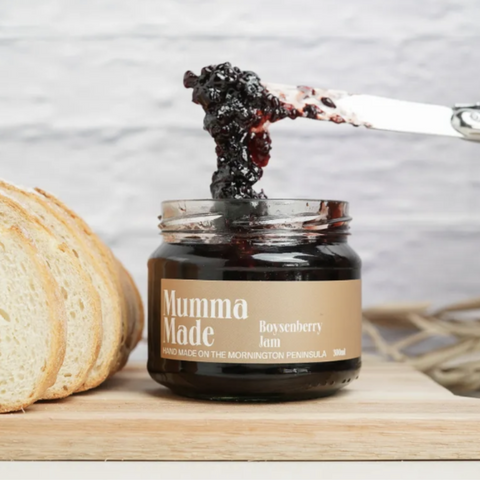 Jar of Boysenberry Jam with a knife spreading jam on bread, branded 'Mumma Made'.