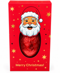 A red Christmas-themed gift box with a cartoon Santa face and a large oval cutout showing a wrapped red chocolate egg inside. The box is decorated with gold stars and the text 'Merry Christmas!' at the bottom.
