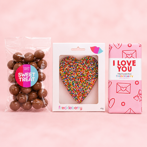 Freckleberry chocolate products including a bag of chocolate raspberries, a heart-shaped chocolate, and a pink box with 'I Love You' text on a pink background.