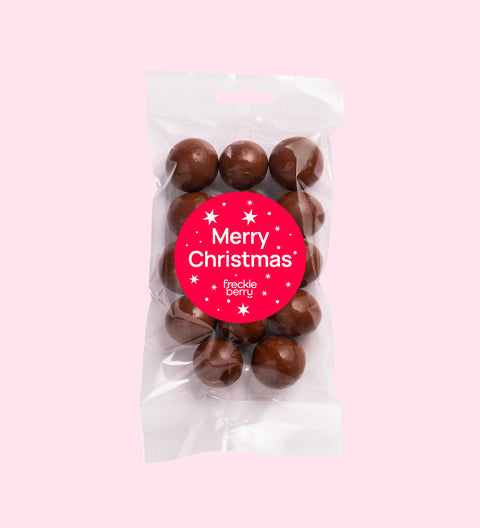 Crunchy macadamias coated in smooth Belgian milk chocolate with "Merry Christmas - Stars" label/design, perfect for festive gifting and snacking.