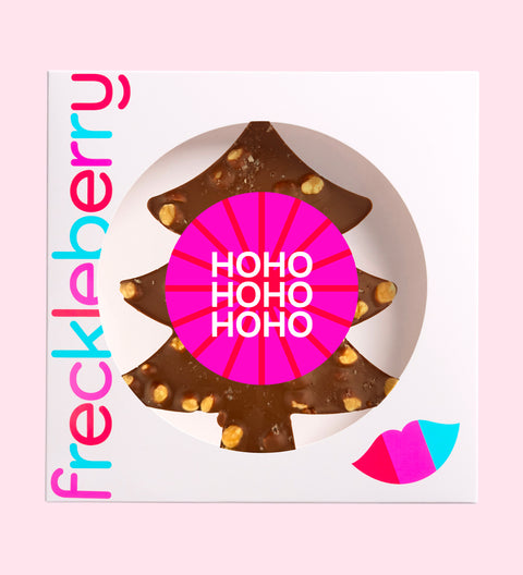 A festive Belgian milk chocolate tree loaded with roasted hazelnuts, gooey caramel, and a sprinkle of sea salt with "HoHoHo" label/design. 