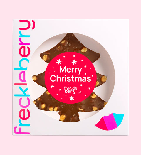 A festive Belgian milk chocolate tree loaded with roasted hazelnuts, gooey caramel, and a sprinkle of sea salt with "Merry Christmas - Stars" label/design. 