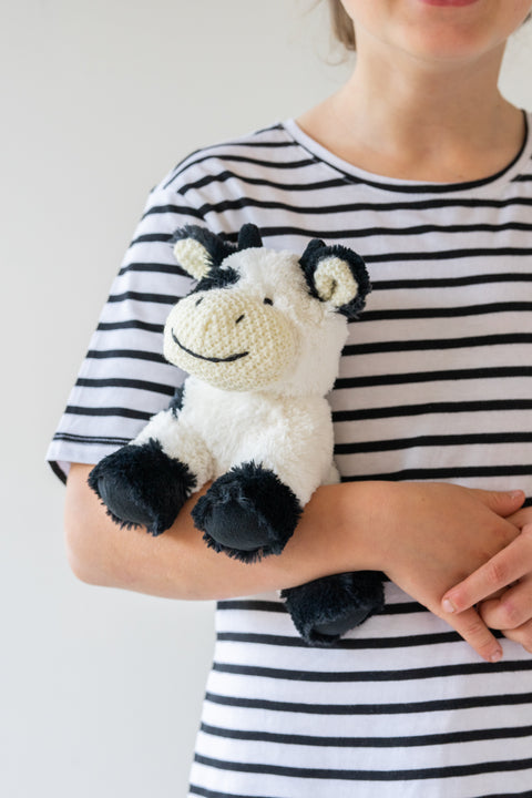 Kid with a soft plush cow toy with a playful spirit and a love for adventure and music. Perfect for cuddles, imaginative play, and thoughtful gifting.