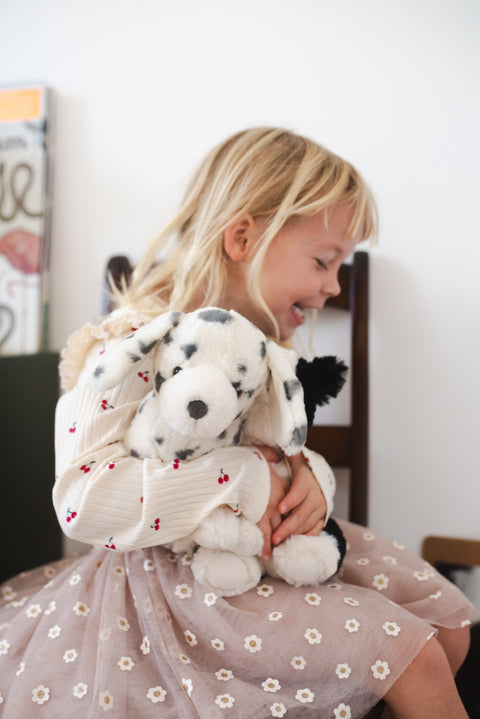 Young girl with soft plush dalmatian toy with lovable spots and a playful spirit. Perfect for cuddles, gifts, and dog enthusiasts.