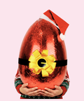 Large chocolate egg wrapped in red foil with a yellow bow, held by a person wearing a Santa hat and Christmas sweater. 6kg Chocolate egg