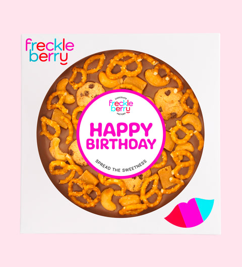 Giant Belgian milk chocolate pizza loaded with pretzels, chocolate chip cookies, caramel fudge, and salted cashews with Happy Birthday sticker, perfect for sharing, gifting, or enjoying any time.