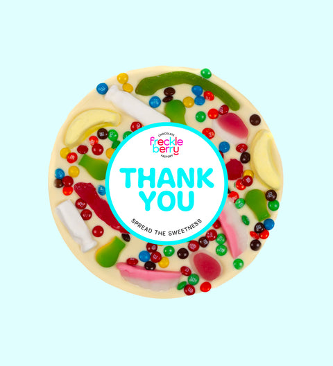 Giant Belgian white chocolate pizza loaded with colourful lollies, personalised with 100mm Thank You sticker, a fun and sweet way to say thanks.