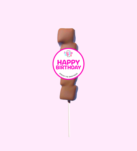 Chocolate cake pop with a 'Happy Birthday' label on a pink background
