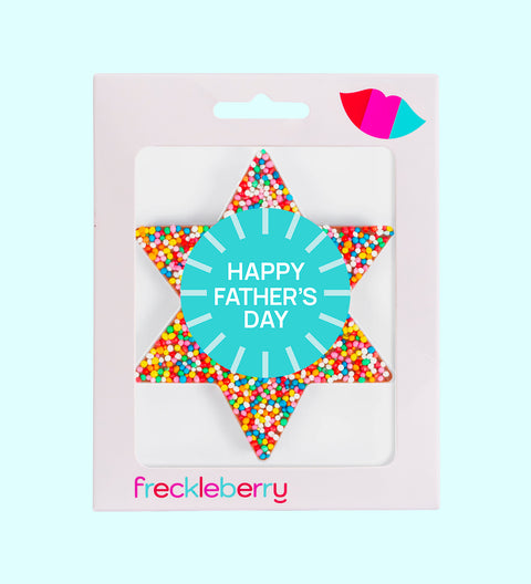 A chocolate freckle in the shape of a star with a 'Happy Father's Day' sticker, multicolored sprinkles, and the brand name 'freckleberry' at the bottom.