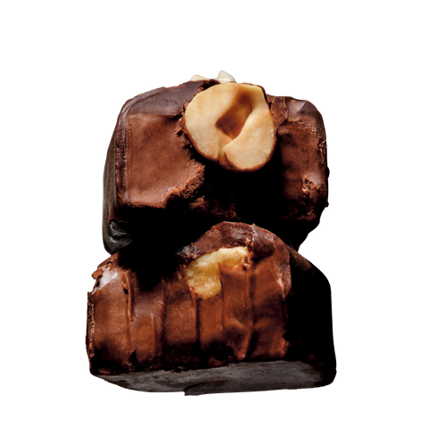 Two stacked chocolate-covered nuts with a halved hazelnut visible in the center, photographed on a plain white background.