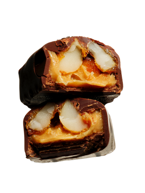 Chocolate-covered treat with caramel and fruit filling on a white background