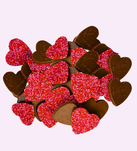 Creamy Belgian milk chocolate freckles shaped like hearts, perfect for gifting or celebrating special moments.