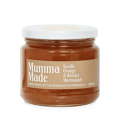 A glass jar of Mumma Made Seville Orange & Whisky Marmalade with a white lid and a tan label, set against a plain white background.